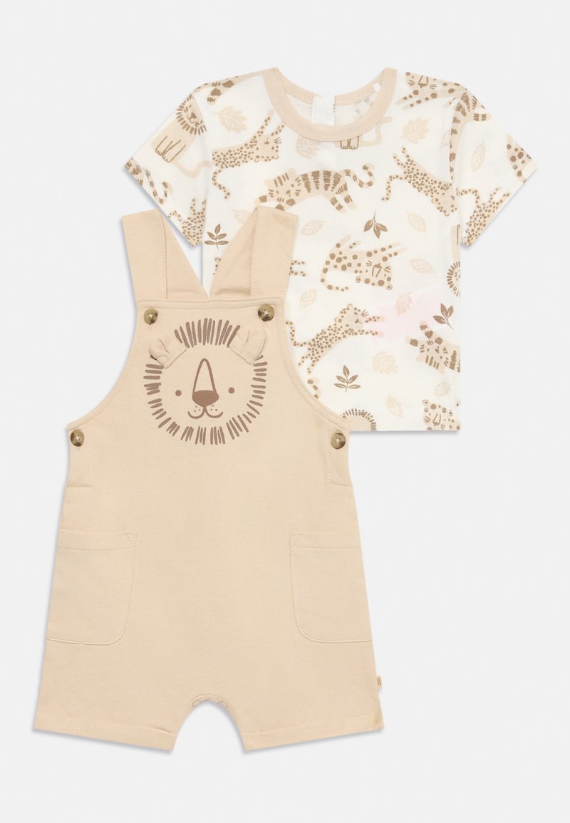 Mono de algodón beige con diseño de cara de león, dos bolsillos y botones en los hombros. Camiseta de crema a juego con patrón de animales en marrón claro.