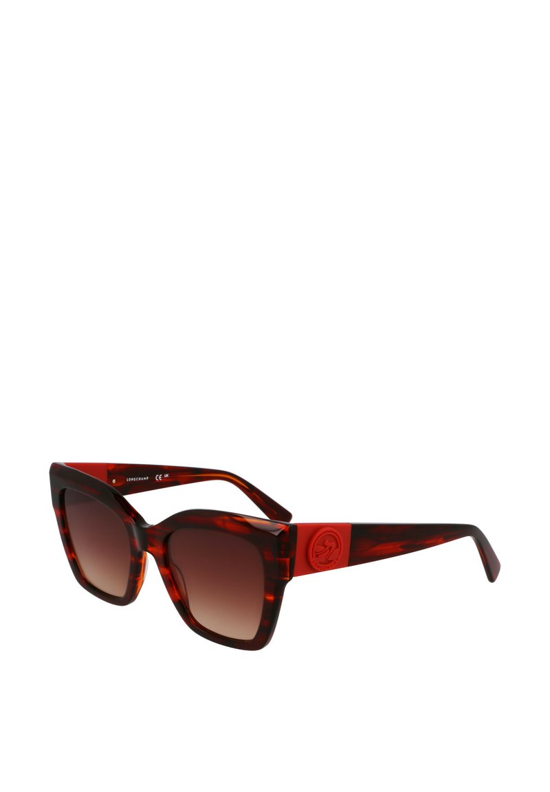 Occhiali da sole tartarugati con un bold design squadrato, lenti marroni sfumate e un accento rosso a contrasto sulla tempia con un dettaglio del logo.