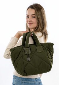 Quilted olive green tote bag with two fabric handles, featuring a chain accent and square patches on the sides.