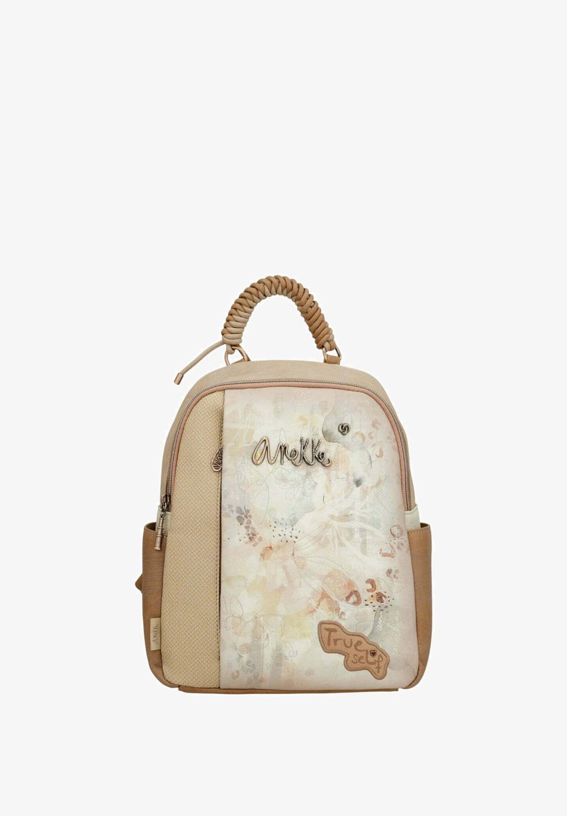 Sac à dos beige avec une façade texturée, arborant des motifs floraux et le texte "Véritable soi." Comprend une poignée tissée en haut et des compartiments zippés.