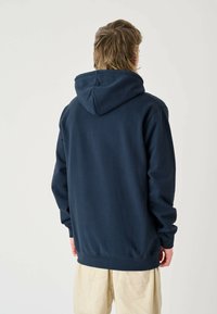 Navy blue hooded sweatshirt with long sleeves, a large hood, ribbed cuffs, and hem. Soft fabric with a smooth texture.
