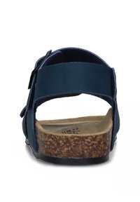 Sandalo blu navy con cinturino posteriore regolabile, suola in sughero e suola in gomma. Presenta un materiale superiore liscia e un design piatto.