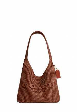 Sac à épaule Coach New York tissé marron avec une seule sangle et une petite étiquette suspendue sur fond blanc.