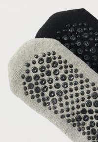 Δύο ζευγάρια κάλτσες αστραγάλου: ένα μαύρο, ένα ανοιχτό γκρι. Και τα δύο διαθέτουν ανάγλυφες λαστιχένιες κουκκίδες στο κάτω μέρος. Μαλακό βαμβακερό ύφασμα.