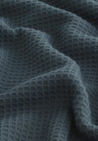 Dunkelblaues, strukturiertes Gewebe mit einem karrierten Muster, das eine weiche, gewebte Optik und einen sanften Fall zeigt. Geeignet für verschiedene textile Anwendungen.