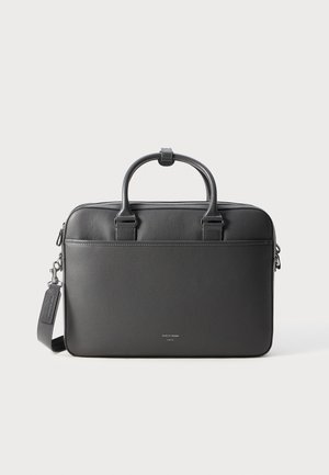 Black leather laptop bag with a textured finish, dual top handles, adjustable shoulder strap, and silver zip closure. Simple and sleek design.