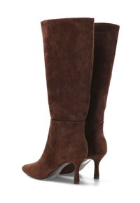 Botas altas hasta la rodilla de ante marrón, con punta puntiaguda y tacón delgado, que presentan una textura suave y un diseño sencillo.