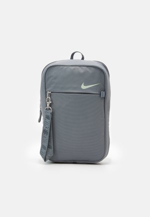 Grauer Nylon-Rucksack mit strukturierter Oberfläche, vordere Reißverschlusstasche und Nike-Logo in Hellgrün. Verfügt über einen oberen Griff und einen gemusterten Schulterriemen.