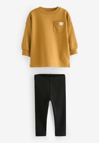 Mosterdkleurige katoenen sweatshirt met een voorkeerzak, gecombineerd met zwarte geribbelde leggings. Beide stukken hebben een eenvoudig, gestroomlijnd ontwerp.
