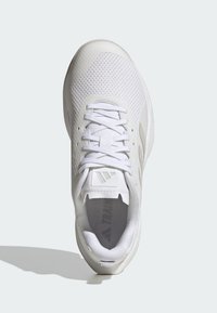 Weißer Sportschuh mit einem Obermaterial aus Mesh, flachen Schnürsenkeln und einem gepolsterten Schaft. Das Design umfasst eine strukturierte Sohle und dezente Markenkennzeichnung auf der Zunge.