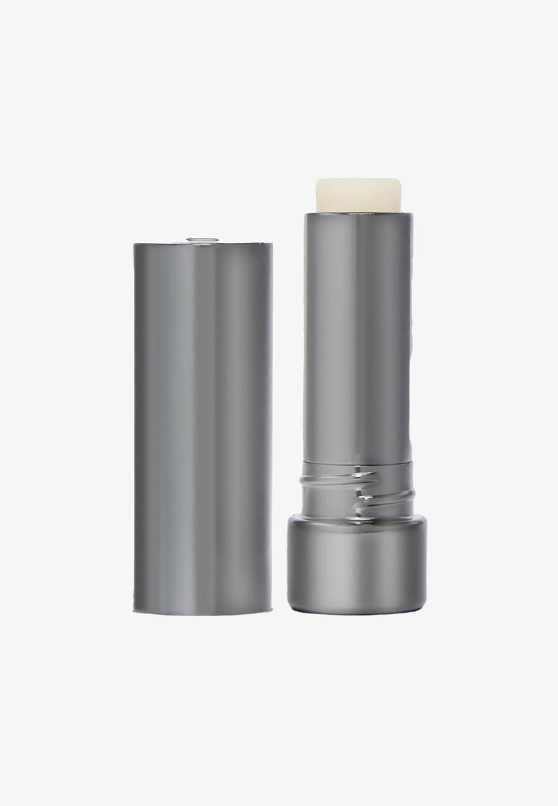 Metallic-silberner Lippenbalsam-Stift ohne Kappe, der den herausgeschobenen hellen Balsam zeigt.