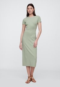 Miętowo-zielona sukienka midi z mieszanki bawełny, z krótkimi rękawami, okrągłym dekoltem i dopasowanym krojem, zestawiona z brązowymi sandałami na paski.