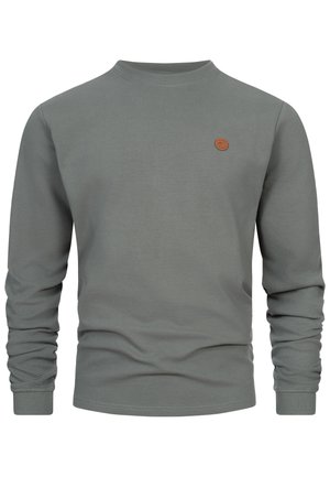 Szary prążkowany sweter z długim rękawem i okrągłym dekoltem, z małą okrągłą brązową naszywką z logo na lewej piersi, dopasowanymi mankietami i luźnym obszyciem w talii.