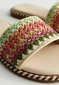 Sandalias de tela tejida con un empeine de paja multicolor que presenta acentos en rosa, verde y azul. Plantilla suave beige y suela trenzada.