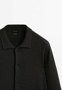 Cardigan gris foncé avec un tricot texturé, doté d'un col polo, d'une fermeture à boutons et de poignets côtelés. Design simple et polyvalent.