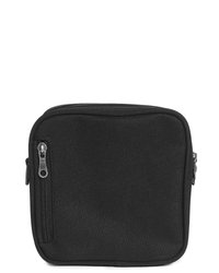 Kompakt svart rektangulär tygpåse med två blixtlås, ett vertikalt på vänstra framsidan och ett längs den övre kanten.