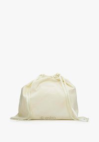 Cotton drawstring bag in cream color, featuring a gathered top and thin, satin-like straps. Subtle logo printed at the bottom.
