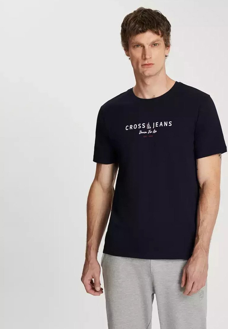 Granatowa bawełniana koszulka z krótkimi rękawami, z białym logo "CROSS JEANS" na przodzie. Okrągły dekolt i luźny krój.