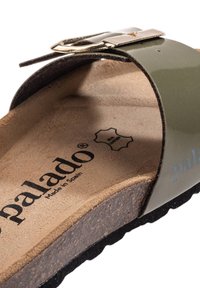 Green patent slide sandal with a gold buckle, cork footbed, and textured black sole. Branding visible on the footbed, "palado Made in Spain."