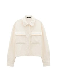 Cropped-Jacke aus cremefarbenem Cord mit klassischem Kragen, Knopfverschluss und zwei vorderen Taschen mit gerippter Textur. Weicher Stoff.