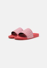 Rode slide sandalen met een brede, gepatterneerde band met witte geometrische ontwerpen en een gestructureerde zool voor grip. Plat, open teen ontwerp.