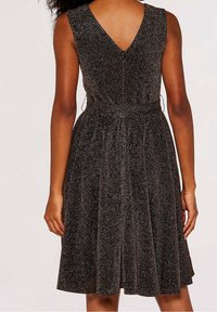 Black sparkly dress with a v-back design. A fitted waist leads to a flared skirt, featuring a textured, shimmering surface.