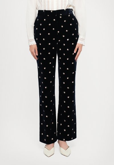 Jūras kara flotes velūra bikses ar ziedu rakstu, kas rotātas ar mazām baltām un rozēm, augsta jostasvieta, platas kājas un gluda tekstūra.