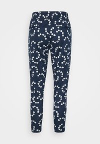 Pantalones de chándal azul marino con cintura elástica, adornados con un patrón de flores blancas dispersas y dos bolsillos traseros para almacenamiento.