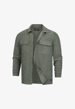Veste chemise en corduroy vert à manches longues avec deux poches à rabat à l'avant, fermeture éclair partielle ouverte et col classique.