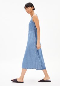 Jeans-Maxikleid mit tailliertem Oberteil und weiter Rock, mit verstellbaren Trägern, in hellblauer Farbe und glatter Textur.