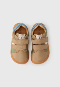 Παιδικά αθλητικά παπούτσια δίχρωμα με μπεζ δερμάτινο επάνω μέρος, πράσινες και μπλε λεπτομέρειες, λουράκια με βέλκρο και καφέ λαστιχένια σόλα.