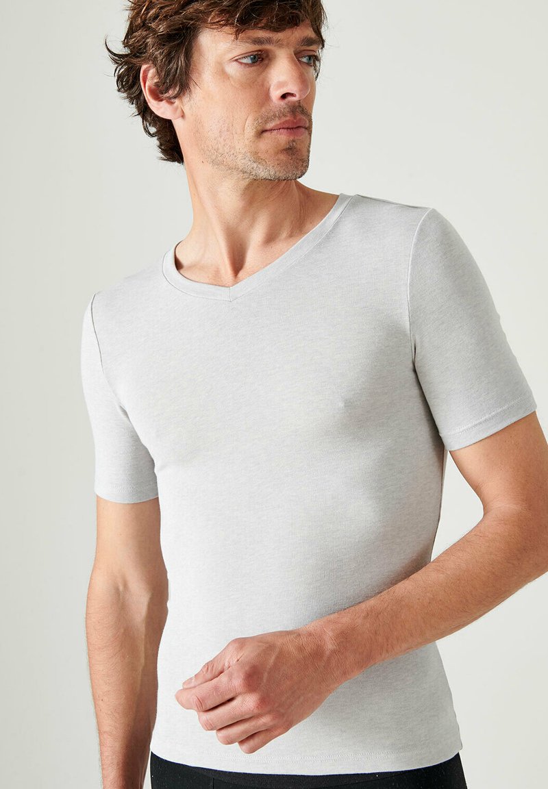 T-shirt in cotone grigio con maniche corte e scollatura a V. Design aderente, texture liscia e stile minimalista. Nessun motivo o accento.