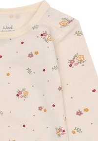 Cremfarbendes Langarmbabyshirt mit kleinen verstreuten Blumenmustern in Pink, Gelb, Rot und grünen Blättern.
