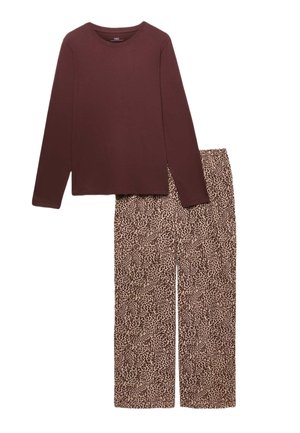 Langærmet mørkebrun top kombineret med løstsiddende beige bukser med et lille mørkebrunt pletteret mønster.