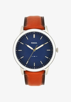 Montre avec un bracelet en cuir brun, boîtier en acier inoxydable argenté, cadran bleu, index des heures dorés et logo de la marque Fossil. Présente un design classique.