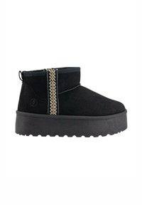 Botines de ante negros con una suela de plataforma texturizada en negro, que presentan un ribete decorativo en dorado y un pespunte blanco a lo largo del costado.