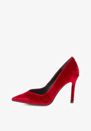 Escarpin en velours rouge avec un bout pointu et un design élégant. Présente une texture lisse et un talon aiguille fin, intérieur noir.