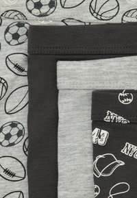 Juego de cuatro pantalones cortos de algodón en tonos de gris y negro. Uno presenta patrones de pelotas deportivas; otro tiene un gráfico con el texto "NY43."