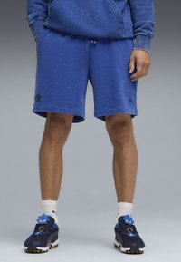 Pantaloni corto in cotone blu con vita elasticizzata e cordino. Presenta tasche laterali e un sottile logo nero sull'orlo.