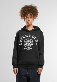 Juodas džemperis su priekinėmis kišenėmis ir didele balta grafika „LOVERS CLUB“, papildyta rožės piešiniu. Minkšta medžiaga, laisvas krova.