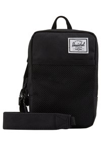Sac bandoulière Herschel noir avec poche avant en maille, patch de marque blanc, et bandoulière réglable sur fond blanc.