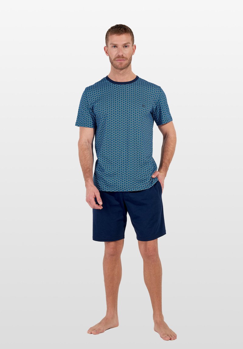 Marineblaues T-Shirt mit kurzen Ärmeln und geometrischem Muster sowie Rundhalsausschnitt, kombiniert mit dunkelblauen Shorts. Beide Teile aus weichem, atmungsaktivem Stoff.