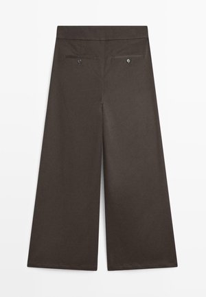 Braune weit geschnittene Hose aus glattem Stoff. Mit flachem Taillenbund, zwei Gesäßtaschen mit Knopfverschluss und genähten Säumen.