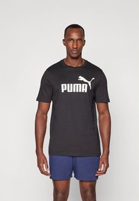Svart kortermet T-skjorte i bomull med en stor hvit "PUMA"-logo og en silhuett av en sprangende katt på brystet.