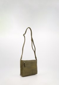 Olive green leather crossbody bag with adjustable strap, zippered front pocket, rectangular shape, and smooth texture.