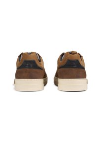 Brown leather sneakers with suede accents, rounded shape, cushioned soles, contrasting black details, and fabric pull tabs at the back.