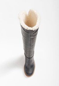 Botte noire en cuir montant jusqu'aux genoux avec une doublure en fausse fourrure crème sur le dessus. Caractéristiques : texture lisse, bout arrondi et semelle cousue.