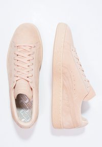 Ljust rosa mockaskor med en strukturerad gummisula, med snörning framtill, vadderad krage och diskret logotyp på tungan.