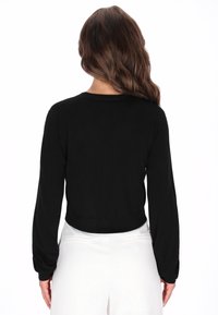 Fekete, rövidített pulóver hosszú ujjakkal, bordázott mandzsettákkal és kerekített nyakkivágással. Simább textúra, minimalista mintázat nélküli dizájn.