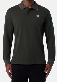 Polo à manches longues en coton vert foncé, avec un col gris aux accents orange et un logo rond sur la poitrine.